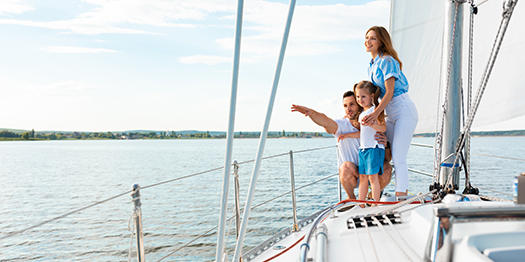 Happy family on yacht pointing at the ocean